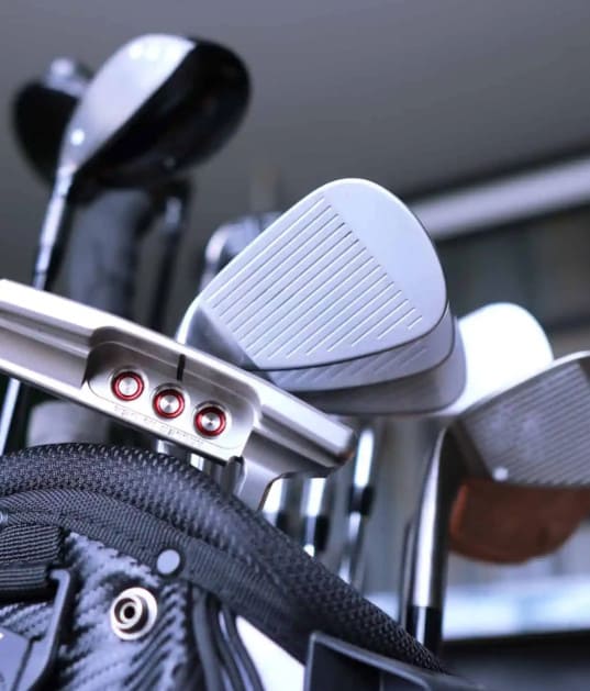 A group of golf clubs placed in the black golf bag