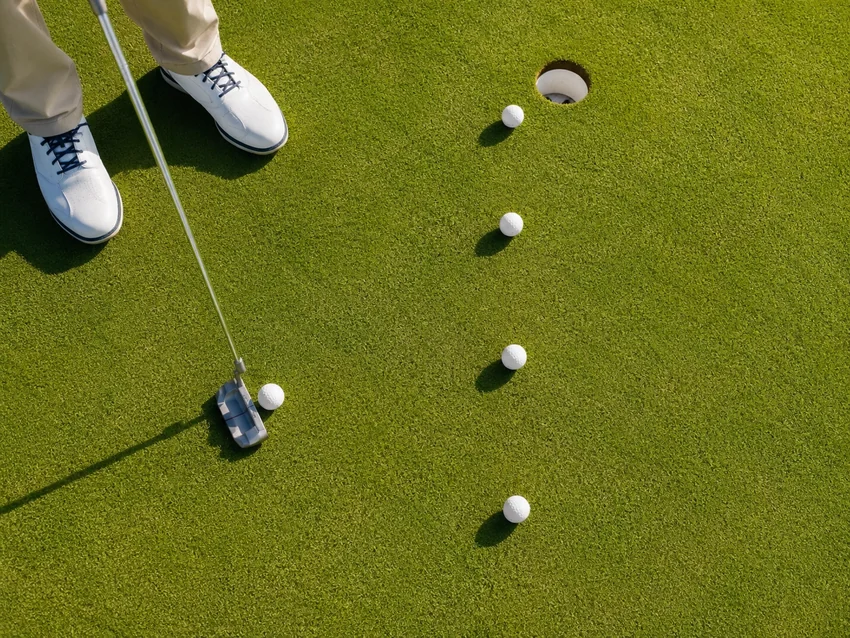 Golfer completing a swing while another golfer watches